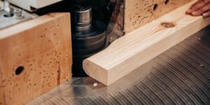 close-up of wood being shaped on spindle moulder at custom millwork company studio